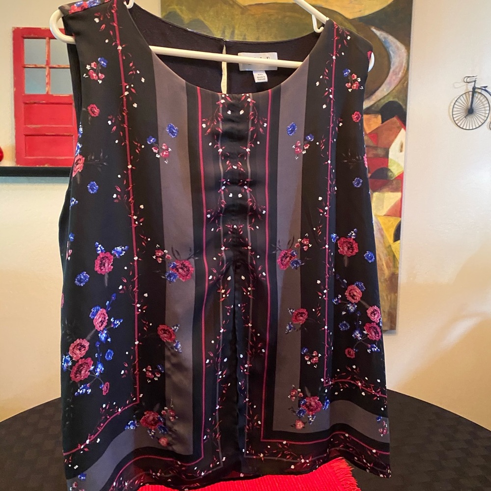 Sleeveless blouse black with small blue flowers.